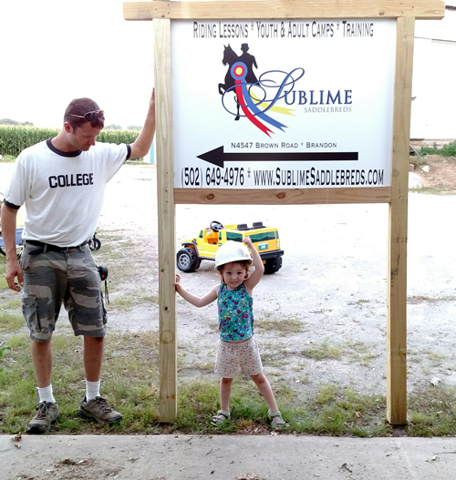 Kennedy helping Nick build the Sublime sign by the road.